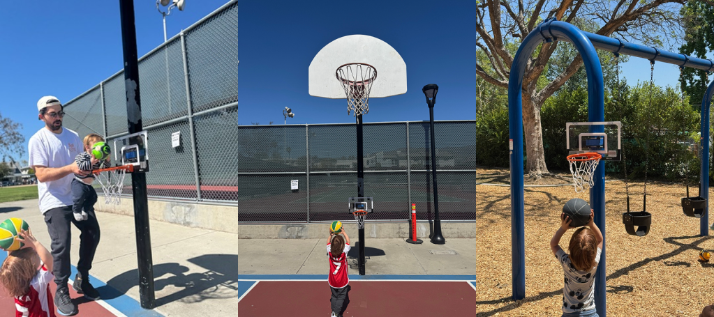 A man holding a child while assisting them to shoot a basketball at a hoop in a park.